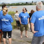 Mehrere Personen Im Blauen Team Altes Fieber Shirt Bereiten Sich Am Flussufer Gemeinsam Auf Eine Veranstaltung Vor.