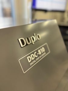 Nahaufnahme Des Logos Und Modellnamens Der Duplo Ddc-810 Digital Spot Uv Coater Maschine – Druckerei Hemmersbach