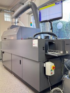 Moderne Digitaldruckmaschine In Der Druckerei Hemmersbach Mit Steuerungsmonitor Und Förderband – Druckerei Hemmersbach