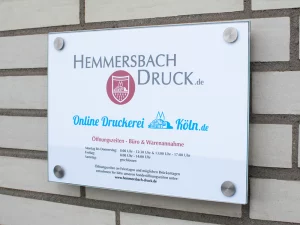 Firmenschild Der Hemmersbach Druck Gmbh &Amp; Co. Kg Mit Logo Und Öffnungszeiten An Einer Ziegelwand – Druckerei Hemmersbach