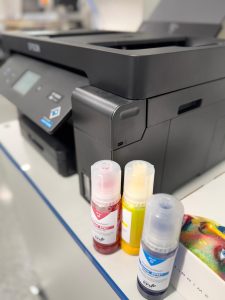 Epson Drucker Mit Drei Flaschen Epson Epn+ Sublisplash Sublimationstinte In Magenta, Gelb Und Cyan Auf Schreibtisch