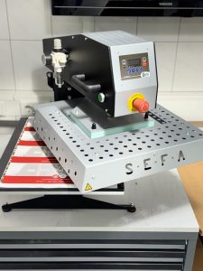 Professionelle Sefa Heißtransferpresse Mit Digitaler Steuerung, Platziert Auf Werkbank Im Druckereiumfeld